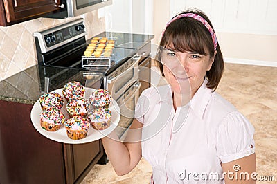 Homemaker holding plate of cupcakes Stock Photo
