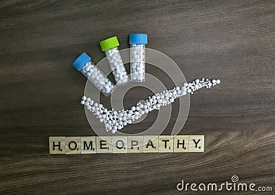 Homeopathy concept. Homeopathic medicine bottle with right mark and Homeopathy text on wood background Stock Photo