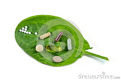 Homeopathy - A homeopathy concept with homeopathic medicine and food supplement on green leaves Stock Photo