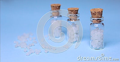 Homeopathy pills in vintage bottles on blue background Stock Photo