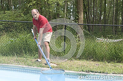 Homeowner cleaning swimming pool Stock Photo