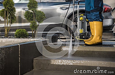 Homeowner Washing His Garden Paths and Driveway Using Pressure Washer Stock Photo