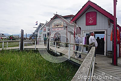 Homer, Alaska: Tourists stroll the wooden boardwalk to visit the row of colorful shops Editorial Stock Photo