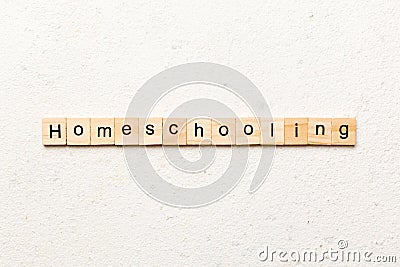 Homeschooling word written on wood block. Homeschooling text on cement table for your desing, Top view concept Stock Photo