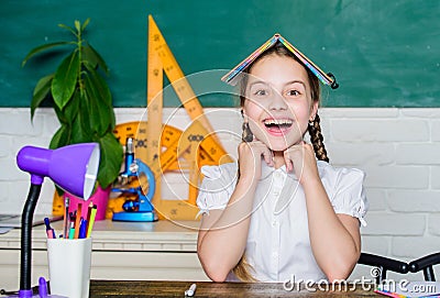 Hometask concept. Girl cute child sit school classroom chalkboard background. Small kid study school. Progress and Stock Photo