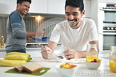 Homosexual Couple Eating Breakfast Cooking In Kitchen Stock Photo