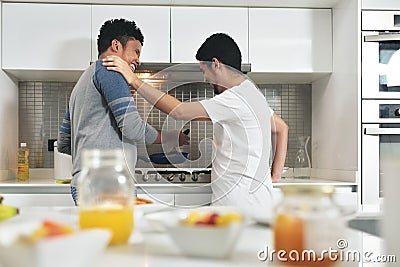 Homosexual Couple Eating Breakfast Cooking In Kitchen Stock Photo