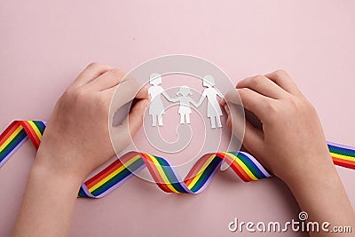 Homosexual family. Different kind of family. Paper cut family simbol with raindow ribbon Stock Photo