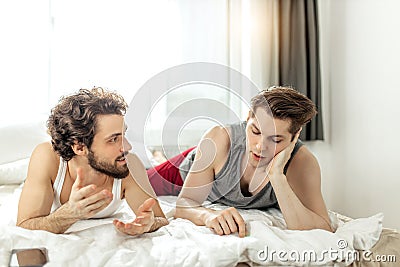 Homosexual married couple talking on bed Stock Photo