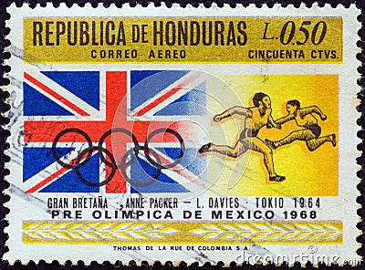 HONDURAS - CIRCA 1968: A stamp printed in Honduras shows Tokyo gold medalists Ann Packer and Lynn Davies with British flag Editorial Stock Photo