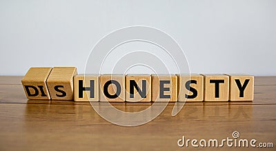 Honesty or dishonesty symbol. Turned cube and changed the word `dishonesty` to `honesty`. Beautiful wooden table, white backgr Stock Photo