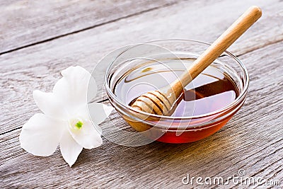 Honey in wooden bowl with honeycomb on wood table backgroun. Stock Photo