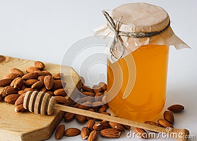 Honey with almonds and hohey spoon Stock Photo