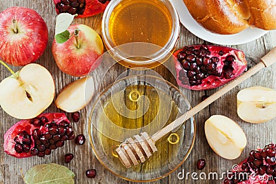 Honey, apple, pomegranate and bread hala, table set with traditional food for Jewish New Year Holiday, Rosh Hashana Stock Photo