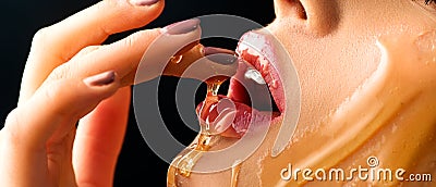 Honey dripping on girl lips. Beauty model woman eating honey Stock Photo