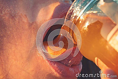 Honey dripping on girl lips. Eating honey. Beauty model woman open mouth, model drinking nectar. Healthy food Stock Photo