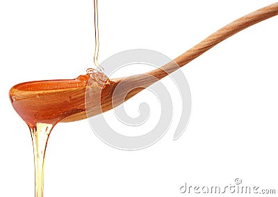 Honey dripping from a wooden honey dipper isolated on white back Stock Photo