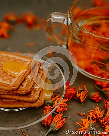 The honey on baked goods. Orange calendula flower tea Stock Photo