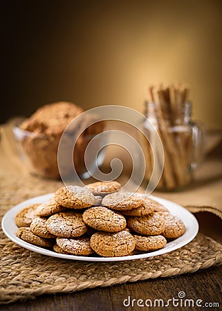 Honey ginger cookies in the foreground. Oatmeal raisin cookies and pirouette rolled wafers in the background. Jute, burlap on woo Stock Photo