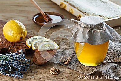 Honey jar and lemon pieces Stock Photo