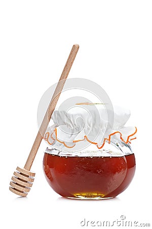 Honey jar and wooden drizzler Stock Photo