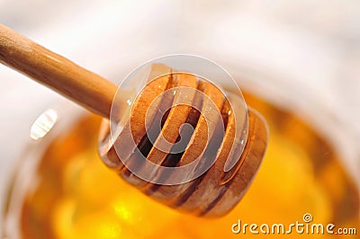 Honey macro with wooden honey dipper in the glass jar Stock Photo