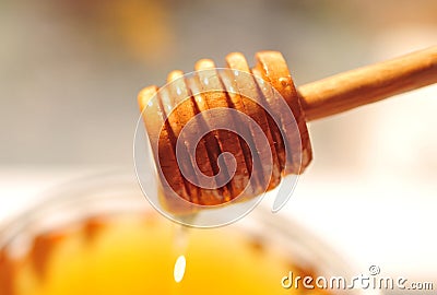 Honey macro with wooden honey dipper and glass jar Stock Photo