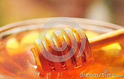 Honey macro with wooden honey dipper in the glass jar Stock Photo