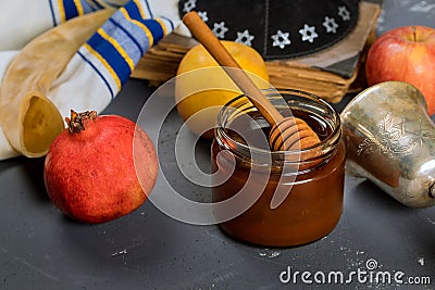 Honey on the pomegranate and apples. Jewishs new year Rosh Ha Shana torah book, kippah yamolka and shofar Stock Photo