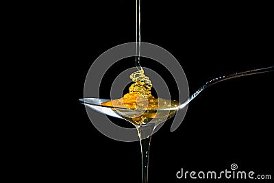 Honey on spoon on black background Stock Photo