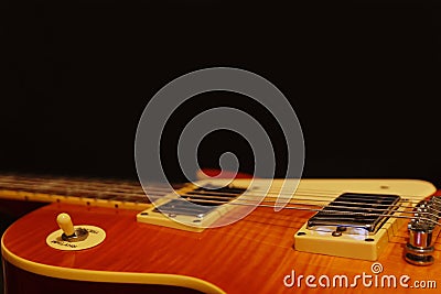 Honey sunburst vintage electric blues guitar closeup on the black background, with plenty of copy space. Stock Photo