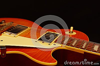 Honey sunburst vintage electric jazz guitar closeup on black background. Shallow depth of field. Stock Photo