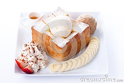 Honey toast with vanilla ice-cream and whipping cream, honey, Strawberry and banana slices Stock Photo