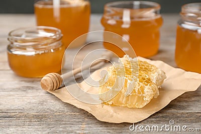 Honeycomb, dipper and jars on table Stock Photo