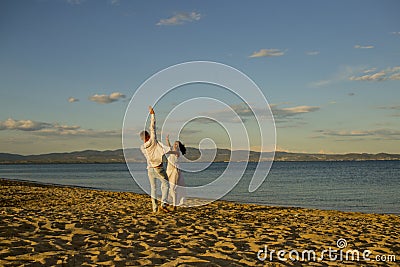 Honeymoon, just married concept. Man and woman dancing, couple happy on vacation. Couple in love running on beach Stock Photo