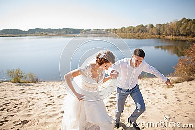 Honeymoon of just married wedding couple. happy bride, groom standing on beach, kissing, smiling, laughing, having fun on beach Stock Photo