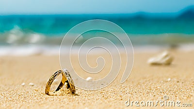 Honeymoon on tropical island, two wedding rings on sandy beach Stock Photo