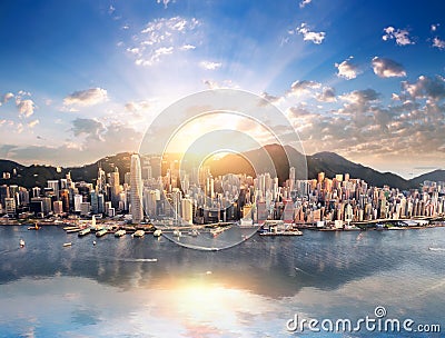 Hong Kong city skyline view from harbor with skyscrapers and sun Stock Photo