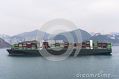Hong Kong - large, fully loaded container ship TALOS approaching to the port terminal. Editorial Stock Photo