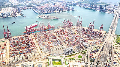 Hong Kong port industrial district with cargo container ship, cranes, car traffic on road and Stonecutters bridge Editorial Stock Photo