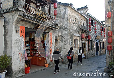 Hongcun Ancient Town in Anhui Province, China. Street with traditional buildings, red lanterns and tourists Editorial Stock Photo