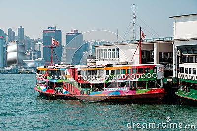 Colorful Star Ferry boat on Tsim Sha Tsui Star Ferry Pier and HongKong Island skyline background Editorial Stock Photo