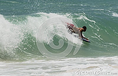 Honolulu, Hawaii - Nov 6, 2021-Man rides shallow surf on a bookey board Editorial Stock Photo