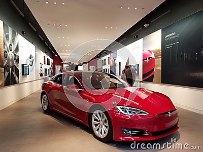 People look at Cars inside Tesla Store Editorial Stock Photo