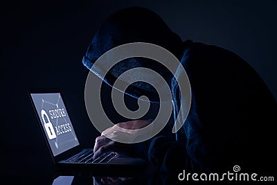 Hooded hacker doing cyber attack to secure access, computer screen Stock Photo