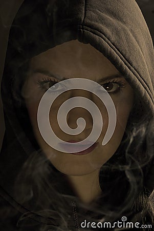 Hooded woman in night with fume Stock Photo