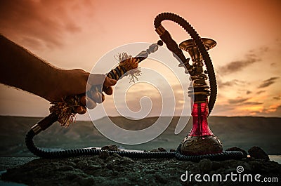 Hookah, traditional arabic waterpipe, direct sunset light, outdoor photo Stock Photo