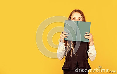 Hooked on book. Small child cover face with book. Little girl read book yellow background. Cute bookworm. Adorable Stock Photo