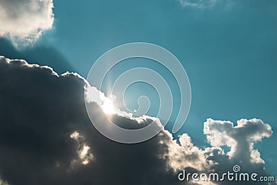 Hope is not lost. sun rising under dark clouds against blue sky Stock Photo