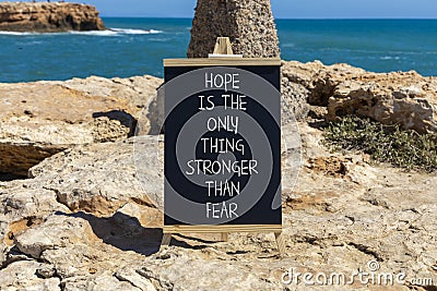 Hope stronger than fear symbol. Concept words Hope is the only thing stronger than fear on blackboard on a beautiful stone Stock Photo